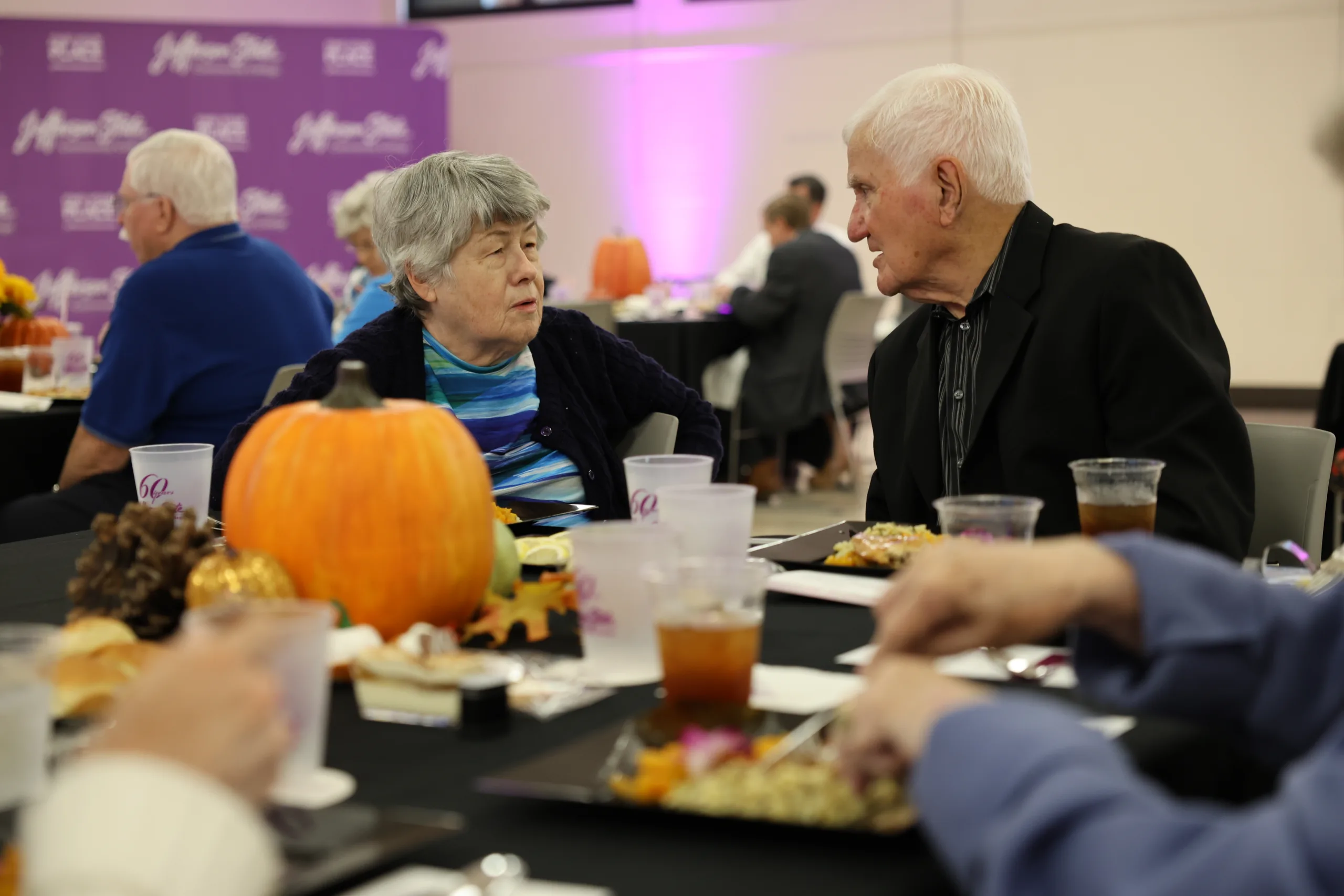 2025 Retiree luncheon attendees talking.