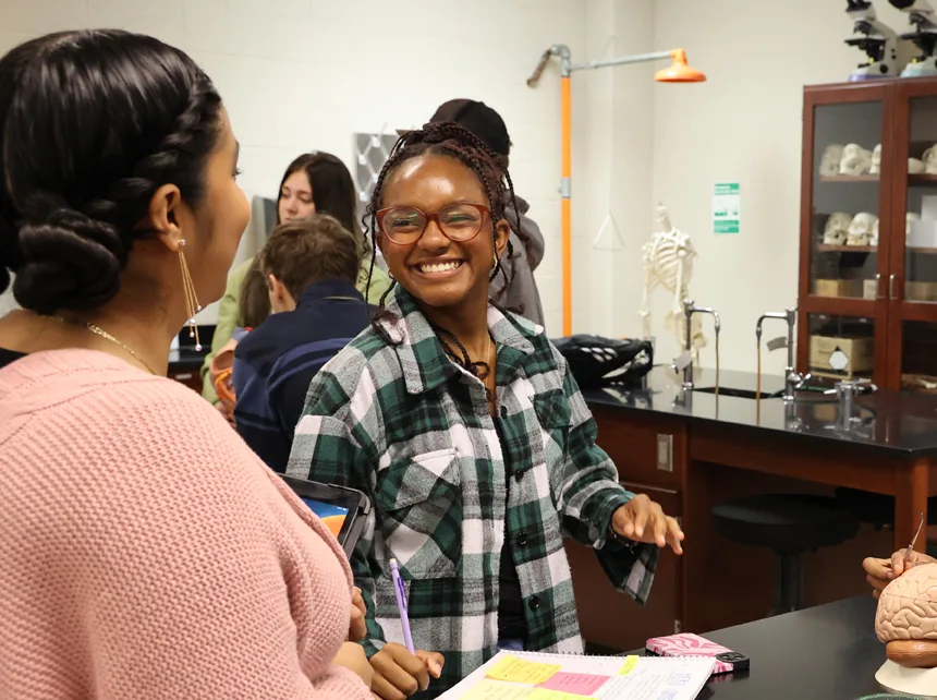 Two students talk in biology lab