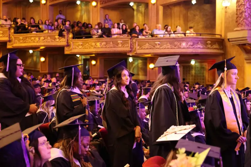 Graduate wait in line for name to be called for diploma