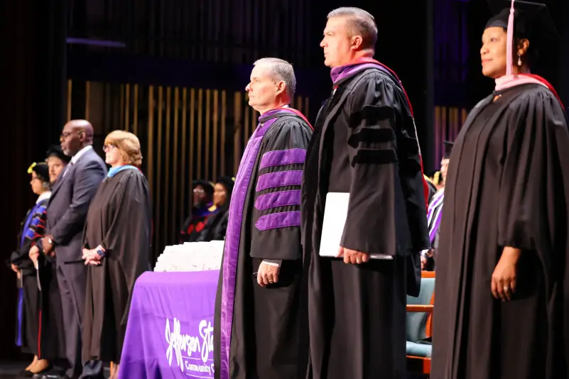President, faculty and Staff stand for graduation cermony