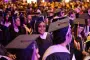 Graduate smile for picture at graduation ceremony