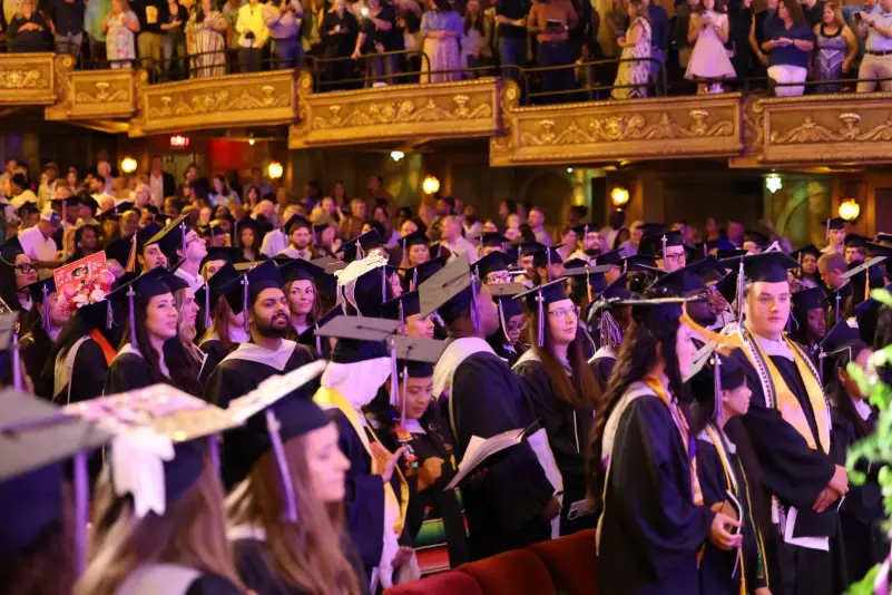 Graduates standing at graduation ceremony