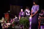 A graduate in cap and gown walks across a stage
