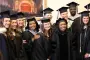Graduates pose with faculty and staff at graduation ceremony