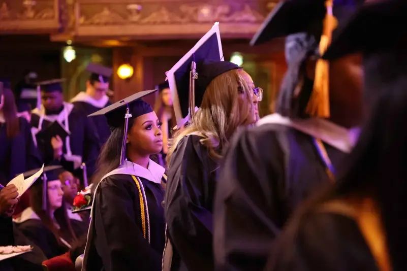 Graduate wait in line for name to be called for diploma